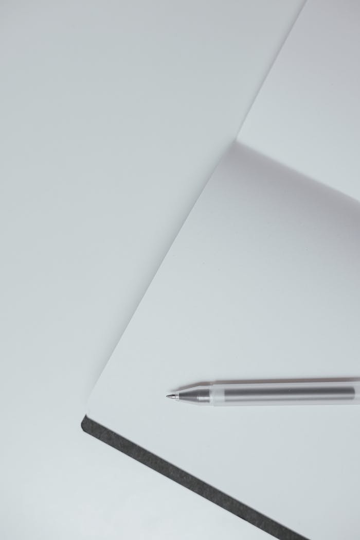 Close-up of a pen resting on an open notebook, featuring ample copy space for text.